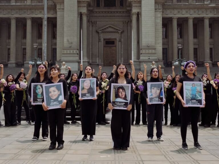 Frauen in schwarz stehen vor einem Behördengebäude in Peru und halten Fotos ermordeter Frauen anklagend hoch.
